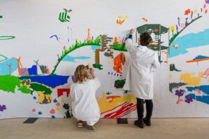 Twee personen maken een schildering op de muur
