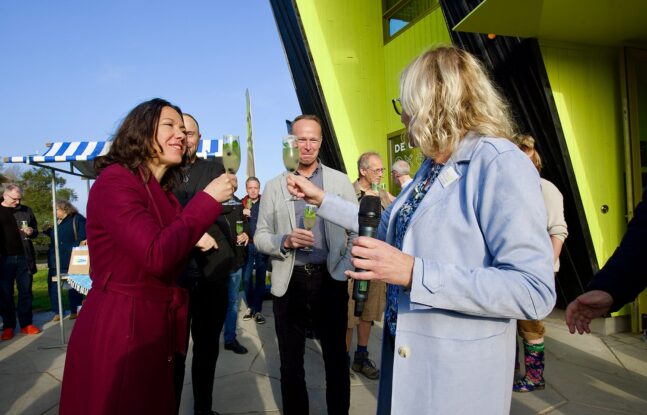 Mensen proosten voor De Oostvaarders tijdens een feestelijke bijeenkomst.