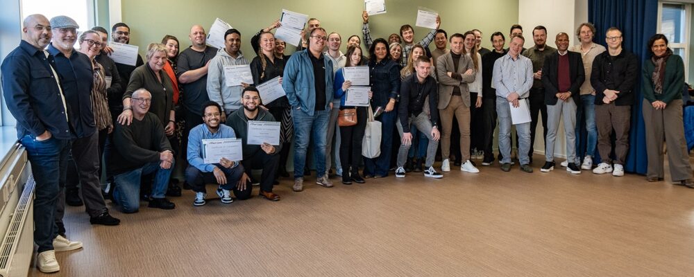 Grote groep studenten van ICT Tribe Almere met tonen hun net behaalde diploma